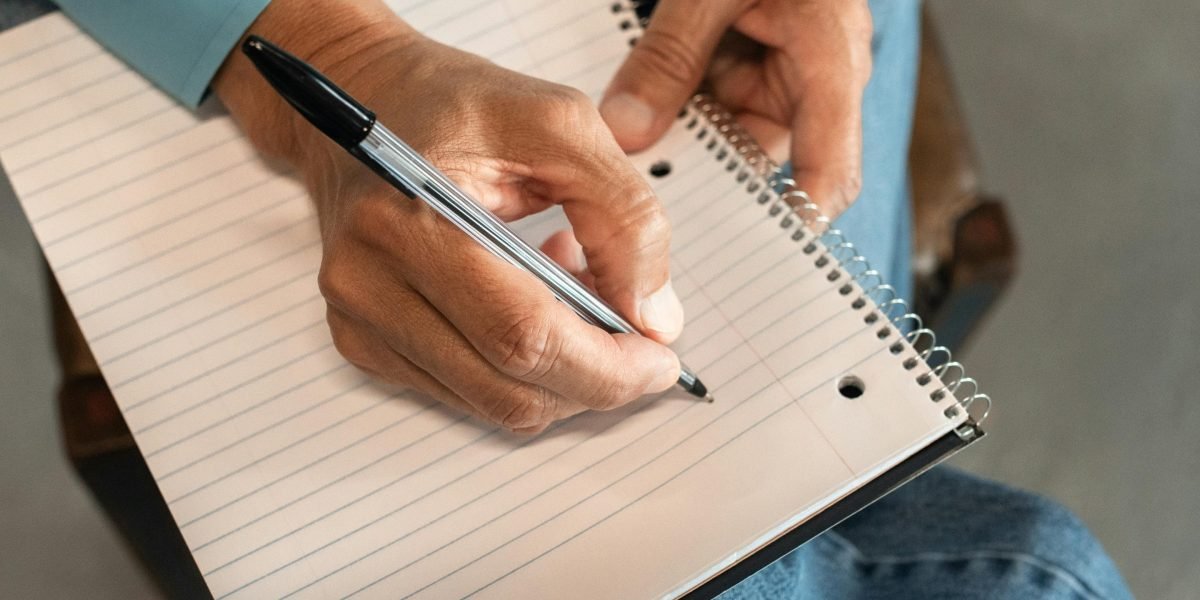 An individual actively engaged in learning, taking notes to reinforce new information and insights.