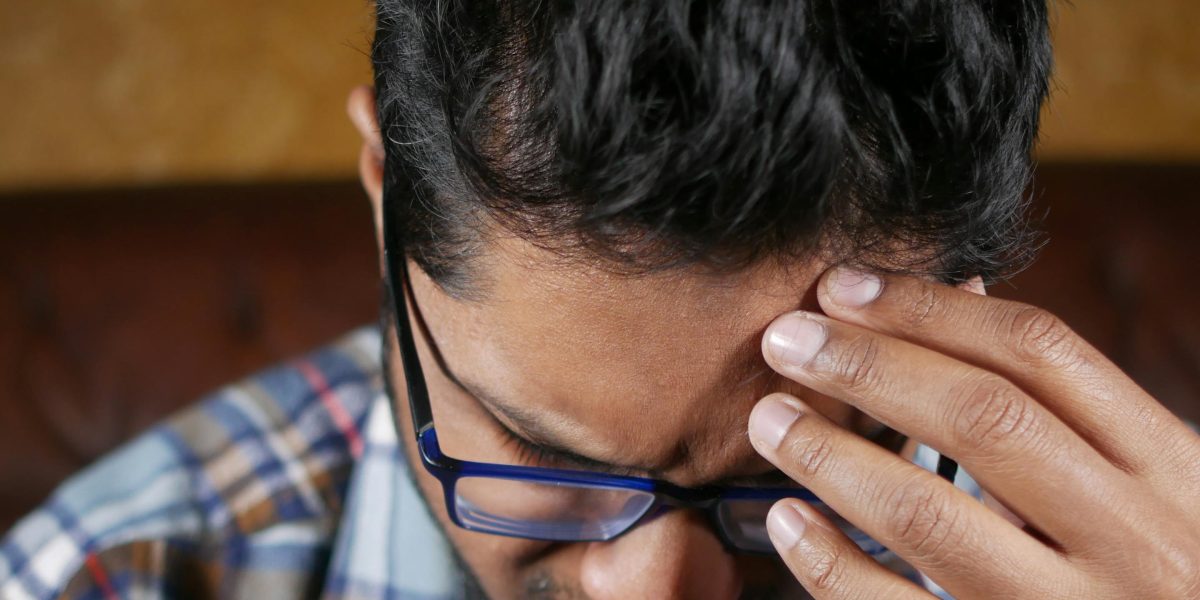 A person experiencing a moment of mental block or difficulty concentrating while trying to work.