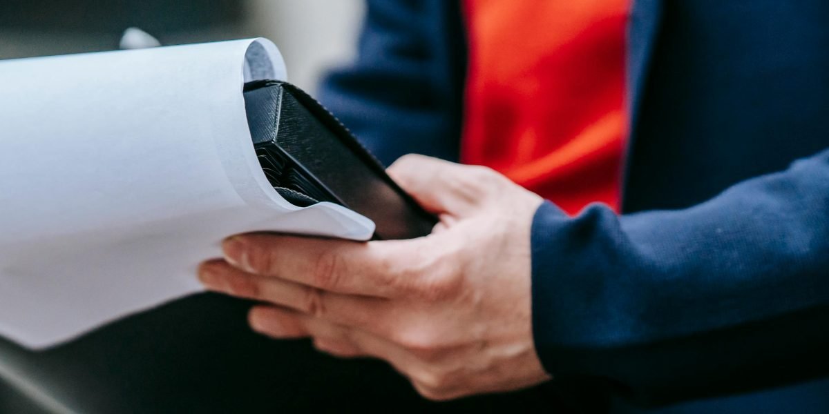 A person thoughtfully reviews policy documents, ensuring compliance and understanding.