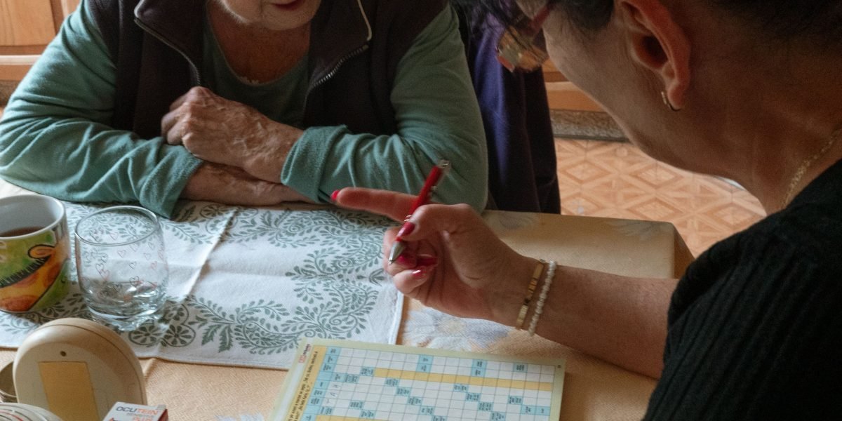 Someone enjoying a crossword puzzle, a classic way to exercise language and memory.