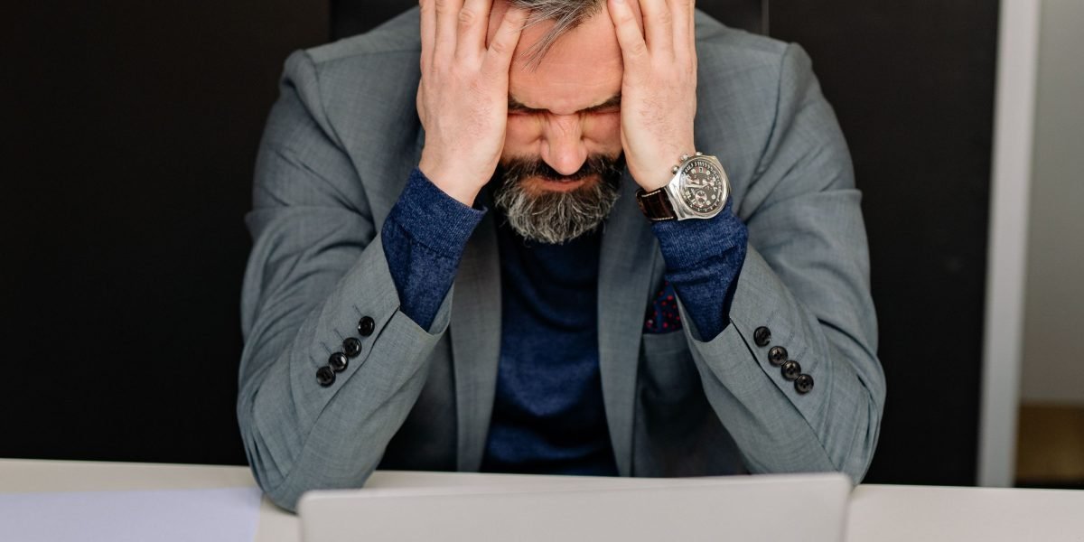 A person appears overwhelmed by multiple information sources, reflecting mental fatigue.