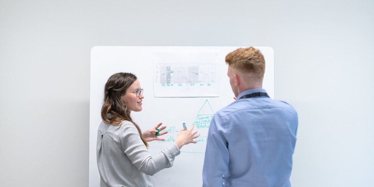 Professionals engaged in a discussion, likely solving a complex problem or brainstorming, reflecting enhanced reasoning skills.