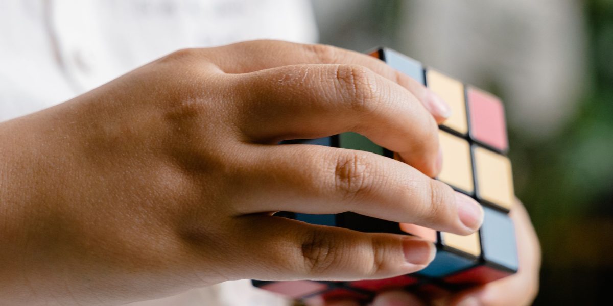 A person quietly absorbed in solving a puzzle, reflecting the calm yet challenging nature of games like Sudoku.