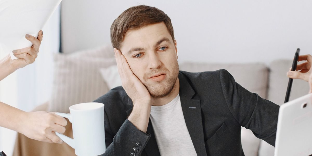 A professional looking overwhelmed amidst numerous tasks, symbolizing information overload.
