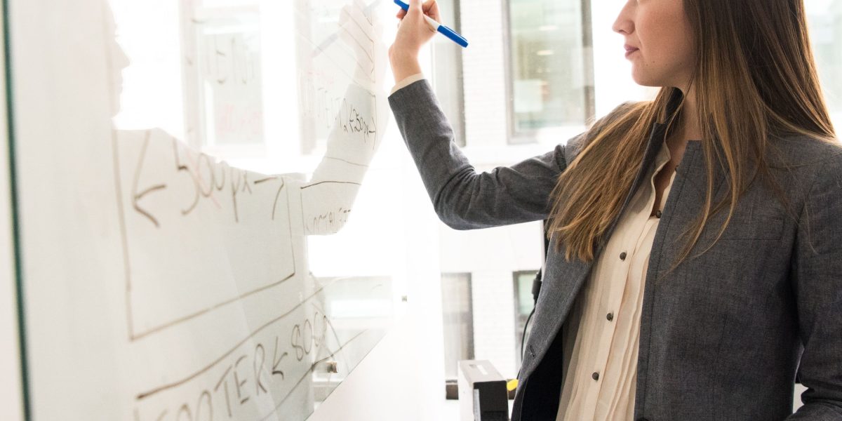 A student actively reviewing and organizing notes on a whiteboard, demonstrating effective study techniques.